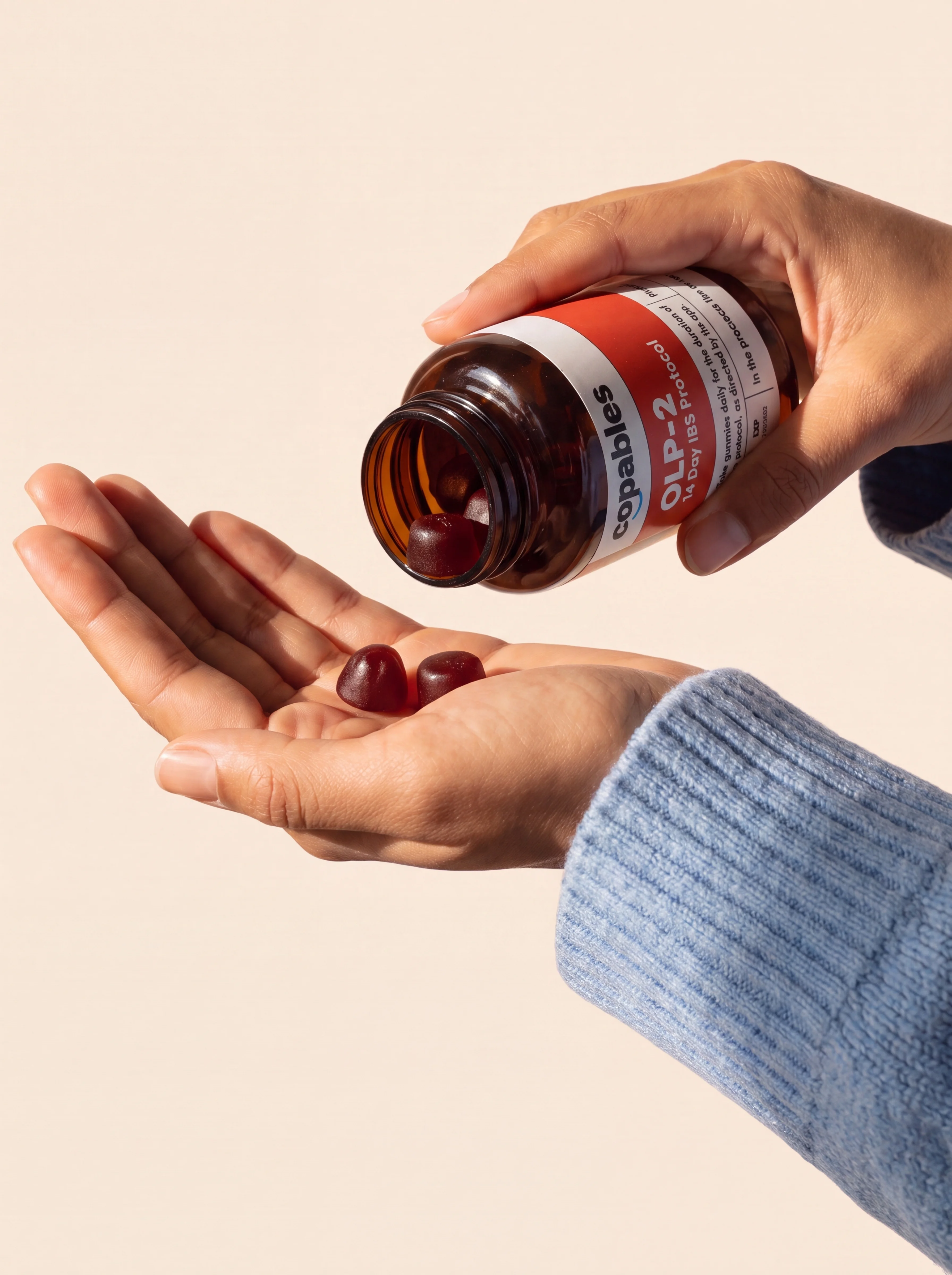 A hand pouring Copables OLP gummies into an open palm, next to a five-star review reading 'I woke up feeling actually rested.'